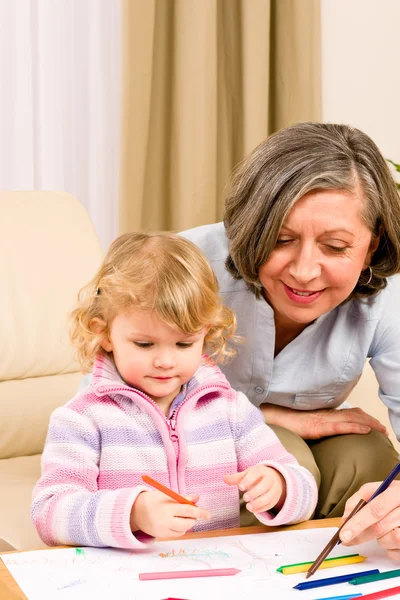 Little girl with grandmother drawing together Stock Photo