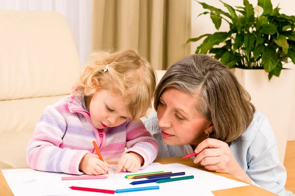 Little girl with grandmother drawing together Royalty Free Stock Images