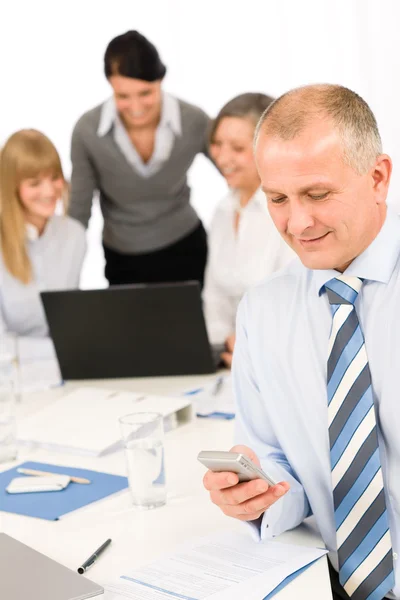 Бизнесмен пользуется телефоном во время командного совещания — стоковое фото