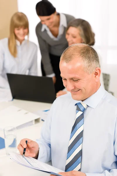 幸せなビジネスマンはチームのミーティング中に報告書を読む — ストック写真