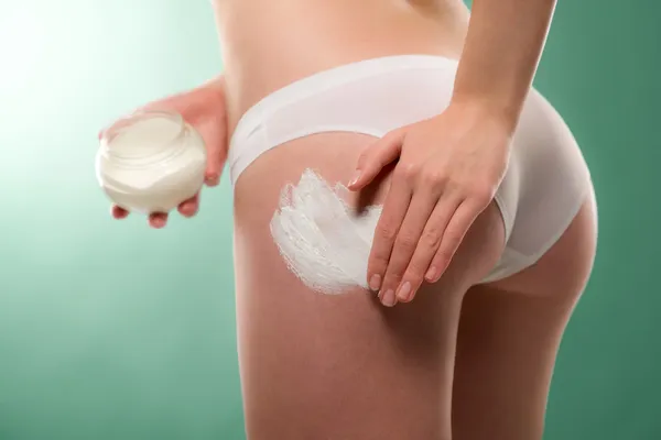 Mujer aplicar crema de celulitis en el fondo —  Fotos de Stock