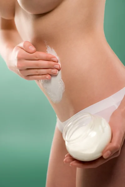Mujer aplicar crema corporal en el vientre —  Fotos de Stock