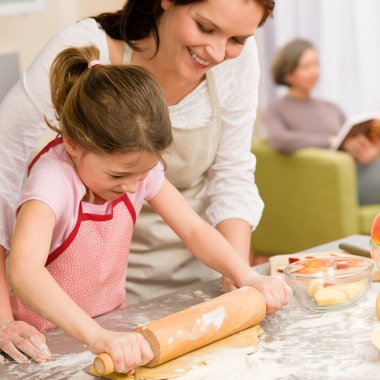 Mother and daughter making apple tart together clipart