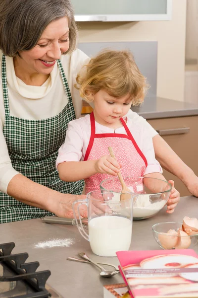 Dítě dívka a babička pečení dortu — Stock fotografie
