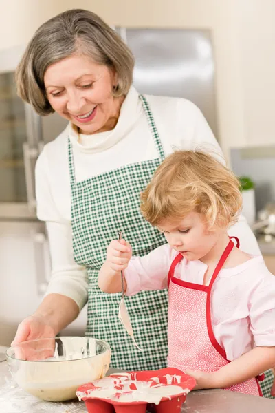 stock image Woman and little girl baking cupcakes together
