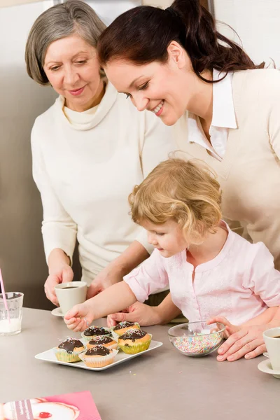 Fille et mère décorant cupcakes saupoudrer — Photo