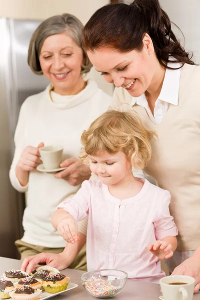 Daughter and mother decorating cupcakes sprinkles — Stock Photo, Image