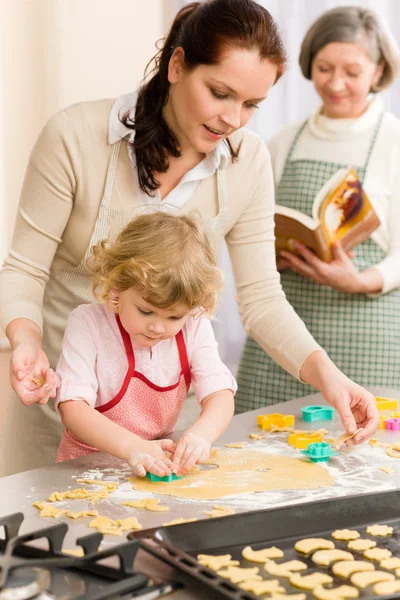 Маленька дівчинка з матір'ю вирізала печиво — стокове фото