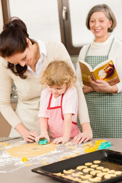 Little girl with mother cutting out cookies — Stock Photo, Image