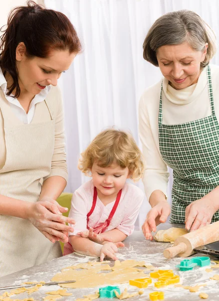 Niña con madre cortando galletas —  Fotos de Stock