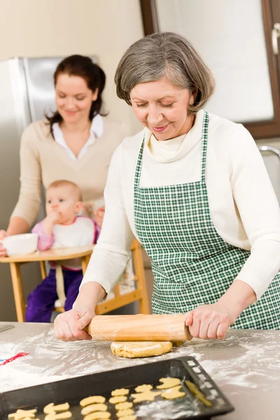 Бабушка катит тесто для печенья — стоковое фото
