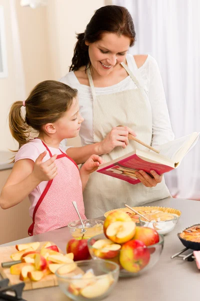 Mother and daughter look baking cookbook — Stock Photo, Image