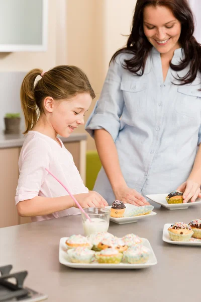 女の子に少し味を振りかけるママとカップケーキ — ストック写真