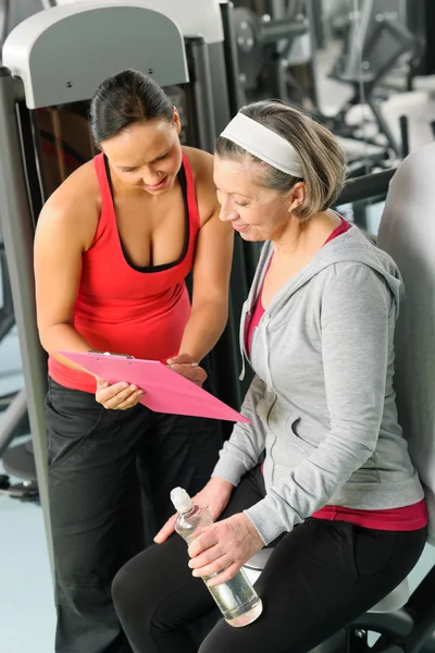 Personal trainer with senior woman at gym — Stock Photo, Image