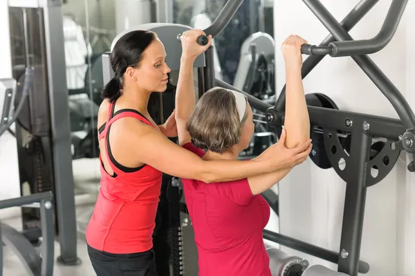 Mulher sênior no centro de fitness ombro exercício — Fotografia de Stock