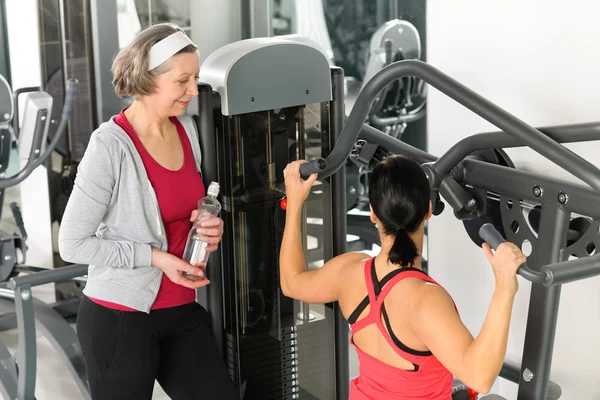 Treinador pessoal no centro de fitness mostrando exercício — Fotografia de Stock