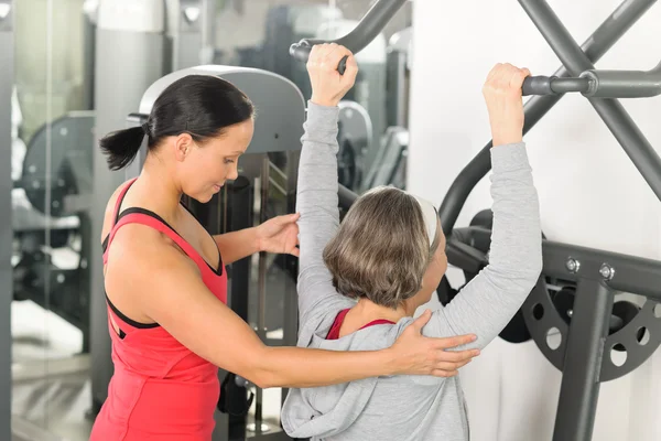 Treinador de centro de fitness ombro de exercício de mulher sênior — Fotografia de Stock