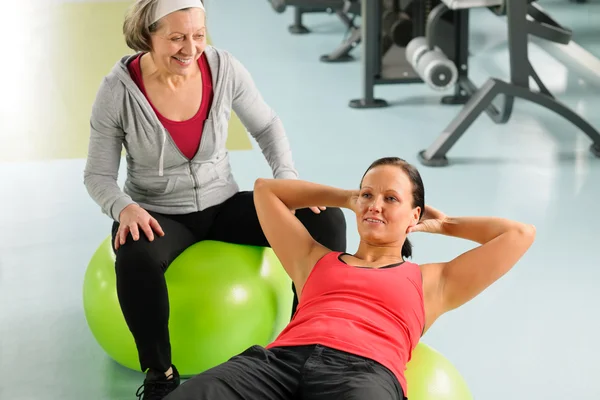 Mujer mayor con entrenador haciendo ejercicio de fitness ball — Foto de Stock