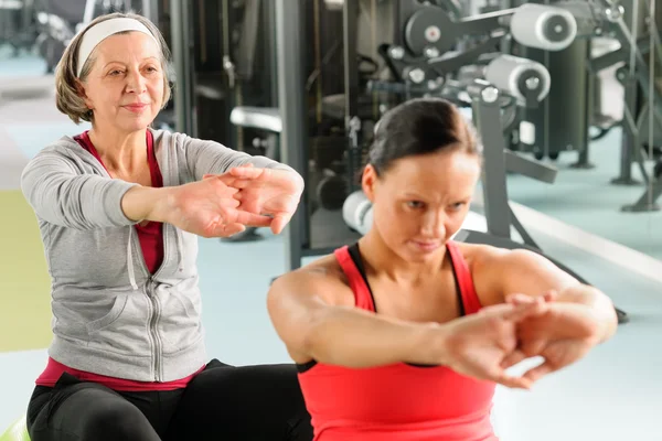 Dos mujeres en el gimnasio se extienden — Foto de Stock