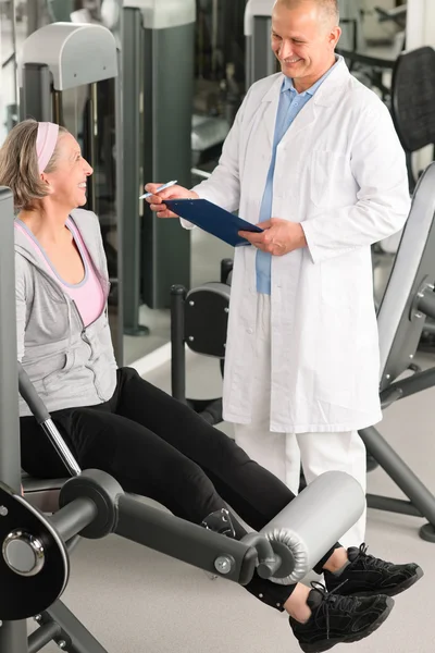 Fysiotherapeut helpen actieve senior vrouw op sportschool — Stockfoto
