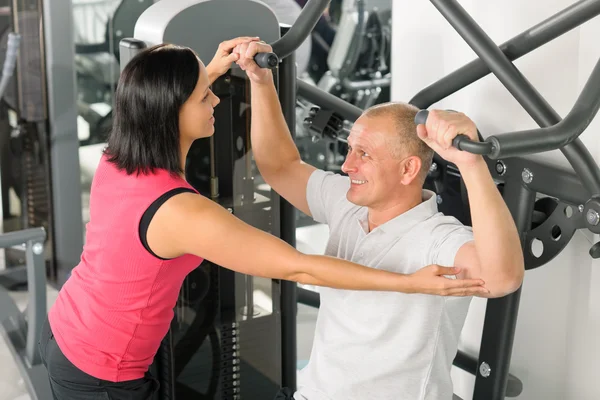 Fitness centrum trainer helpen man oefening terug — Stockfoto