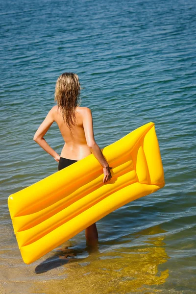 Sommerfrau hält gelbe Schwimmmatte in der Hand — Stockfoto