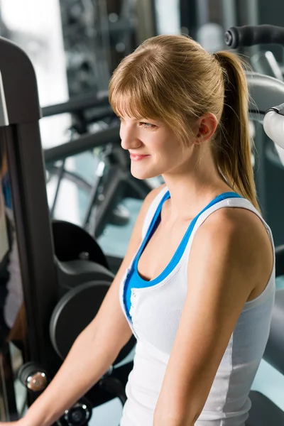 Young woman at fitness center exercise machine — Stock Photo, Image