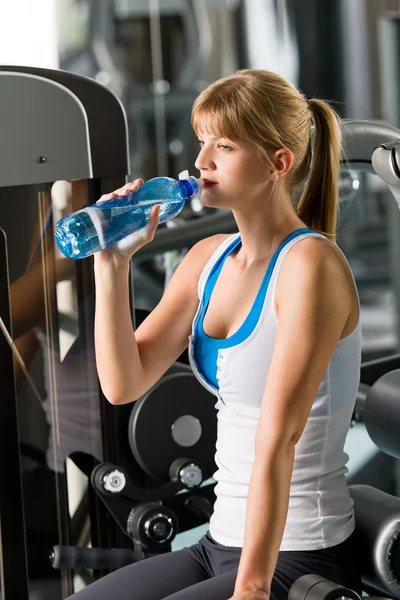 Frau trinkt Wasser an Fitnessgerät — Stockfoto