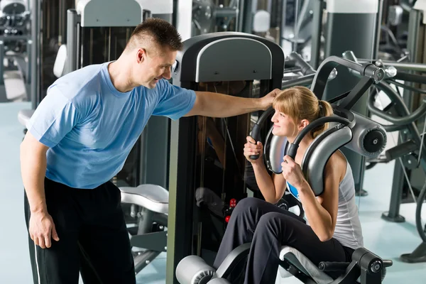 Γυμναστήριο κέντρο άσκηση νεαρή γυναίκα με εκπαιδευτή — Φωτογραφία Αρχείου