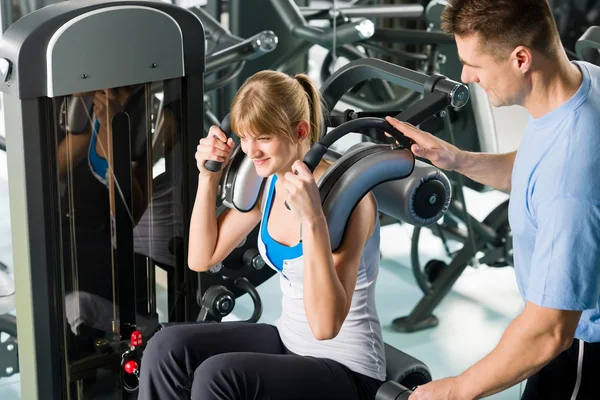 Centro de fitness exercício jovem mulher com treinador — Fotografia de Stock