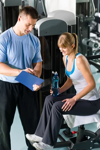 Personlig tränare med ung kvinna på gym — Stockfoto