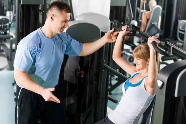 Young woman exercise on shoulder press machine — Stock Photo, Image