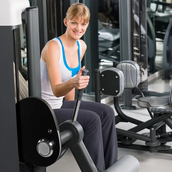 Fiatal nő, a fitness center gyakorlat gép — Stock Fotó