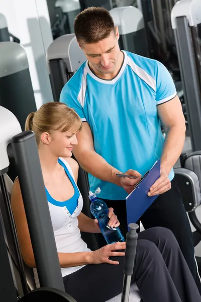 Ελέγξτε το πρόγραμμα άσκησης γυμναστήριο με προσωπικό γυμναστή — Φωτογραφία Αρχείου