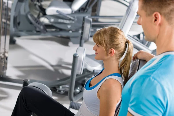 Entrenador personal con una joven en el gimnasio —  Fotos de Stock