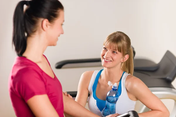 Young female friends chatting in fitness center — Stock Photo, Image