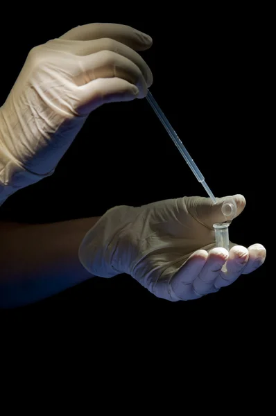 Hands in white gloves hold pipette — Stock Photo, Image