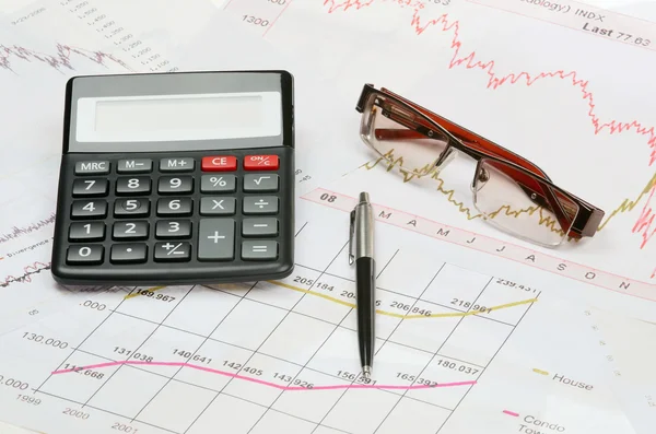 Calculadora e caneta em um gráfico financeiro — Fotografia de Stock