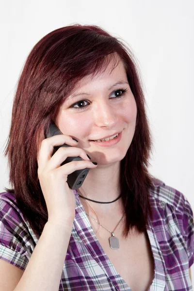 Mulher ruiva jovem está falando com alguém sobre o smartphone isolado no fundo branco — Fotografia de Stock