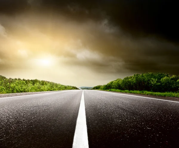 Stormy sky and road in forest Royalty Free Stock Photos