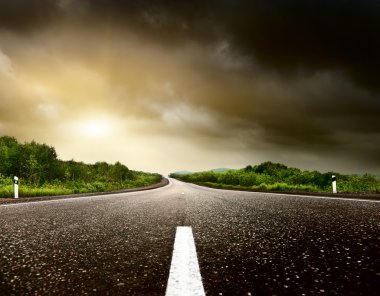 Stormy sky and road in forest clipart