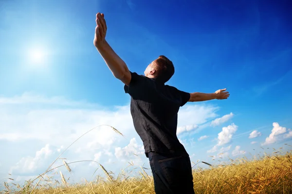 Junger Mann rastet auf Weizenfeld aus — Stockfoto