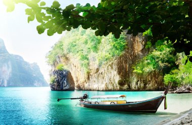 Long boat on island in Thailand clipart