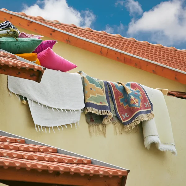 Polštáře a přikrývky leží na Taškové střechy — Stock fotografie