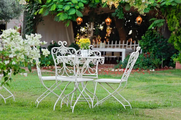 Bílý stůl a židle v krásné zahradě. — Stock fotografie