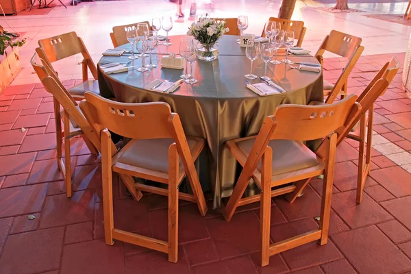 De instelling van de tabel voor een bruiloft in gekleurde verlichting — Stockfoto