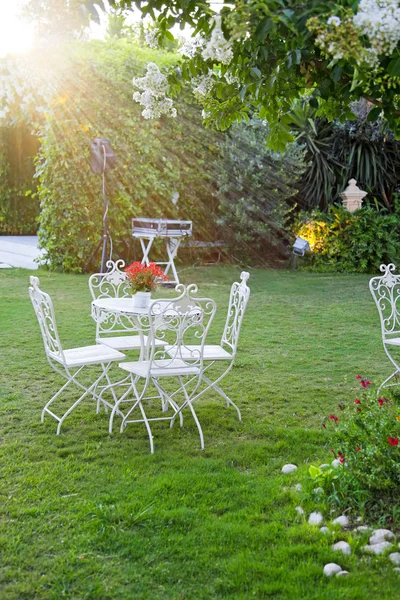 Witte tafel en stoelen in de prachtige tuin. — Stockfoto