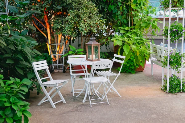Mesa branca e cadeiras em belo jardim . — Fotografia de Stock