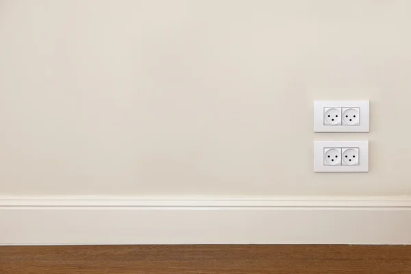 木製の床と電源コンセントと壁 — ストック写真