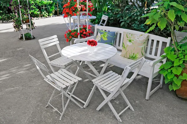 Mobília branca em um belo jardim . — Fotografia de Stock